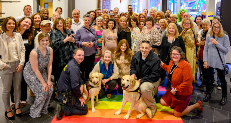 Two service dogs and a crowd of notables from Easton, PA, including Larry Holmes and Mayor Sal Panto, celebrate during a bash at the Sigal Museum.